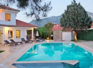 a swimming pool in the backyard of a house with a villa at Villa Kısmet in Fethiye