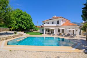 a swimming pool in front of a house at Villa Kısmet in Fethiye