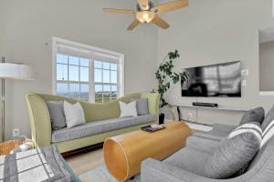 a living room with two couches and a flat screen tv at Oceanfront with Private Beach Access Sunset Views in Sneads Ferry
