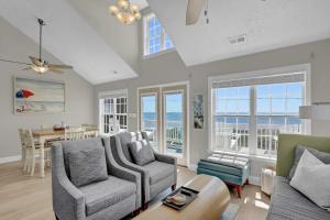 a living room with a couch and chairs and a table at Oceanfront with Private Beach Access Sunset Views in Sneads Ferry
