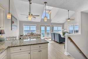 a kitchen with a counter and a living room at Oceanfront with Private Beach Access Sunset Views in Sneads Ferry