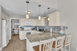a kitchen with white cabinets and a granite counter top at Oceanfront with Private Beach Access Sunset Views in Sneads Ferry +46 photos
