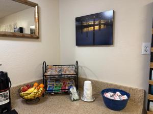 a counter with a basket of fruit and a mirror at Super 8 by Wyndham Florence OR in Florence +16 photos