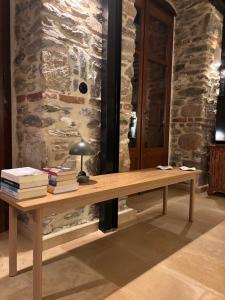 a wooden desk with books and a lamp on it at Dreamy Cottage in Ayiá