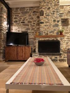 a coffee table in a living room with a stone wall at Dreamy Cottage in Ayiá +21 photos