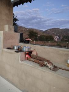 a stove with pots and pans on top of a wall at Sítio Azevedo in Buenópolis