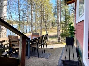 a table and chairs on a porch with a view of the water at House in Beautiful Nature by the Sea Bay with Sauna & BBQ in Salpar
