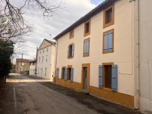 an empty street next to a white building at Suite parentale avec un petit salon in Homps