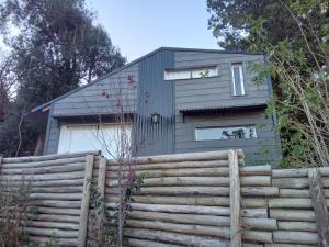 a house with a fence in front of it at Tiny House de montaña in San Martín de los Andes
