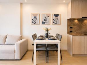 a white dining room table with chairs and a couch at Cozy 1 BR Bangtao Beach in Laguna Phuket