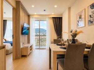 a hotel room with a dining table and a bedroom at Cozy 1 BR Bangtao Beach in Laguna Phuket