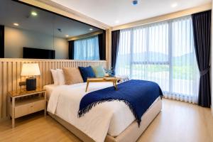 a bedroom with a large bed and a large window at Cozy 1 BR Bangtao Beach in Laguna Phuket