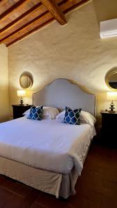 a bedroom with a large bed with blue pillows at Riant Relais de Charme in Greve in Chianti