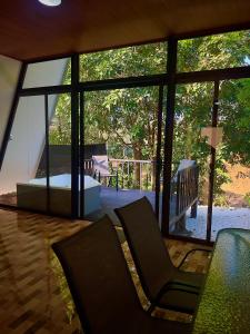 a room with a large window with chairs and a table at Cabañas Rio Brazo in Rio Celeste
