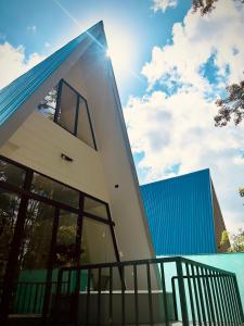 a modern house with a blue roof at Cabañas Rio Brazo in Rio Celeste