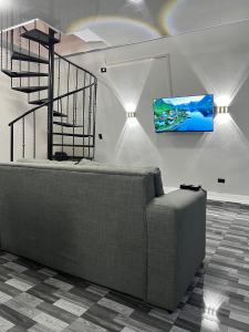 a living room with a couch and a tv on a wall at Cabañas Rio Brazo in Rio Celeste
