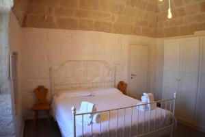 a bedroom with a bed with white sheets and a door at Kasamare- Monopoli in Monopoli