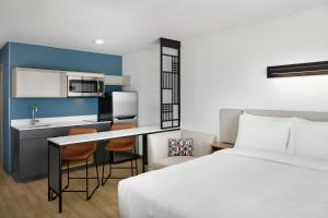 a hotel room with a bed and a kitchen at StudioRes by Marriott Columbia Harbison in Columbia