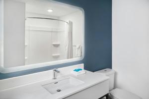 a white bathroom with a sink and a mirror at StudioRes by Marriott Columbia Harbison in Columbia +17 photos