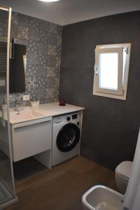 a bathroom with a washing machine and a sink at Kasamare- Monopoli in Monopoli +4 photos