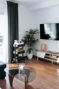a living room with a tv and a table at Home Corinto Beach terraza y piscina - Benalmadena Malaga in Benalmádena