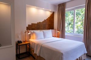a hotel room with a bed and a window at Kaleo Hotel Boutique in San Salvador