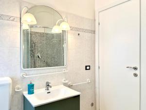 a bathroom with a sink and a mirror at Sea View Apartment - Private Parking AC in Savona +10 photos