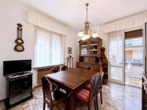 a dining room with a table and a television at Sea View Apartment - Private Parking AC in Savona