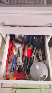 a drawer filled with lots of kitchen utensils at Casa Aconchegante S8km do parque do peão in Barretos