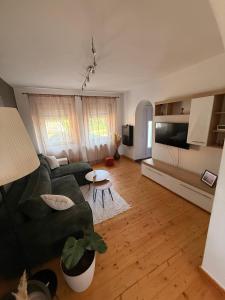 a living room with a green couch and a table at Kuća za odmor Gaia in Vukovar