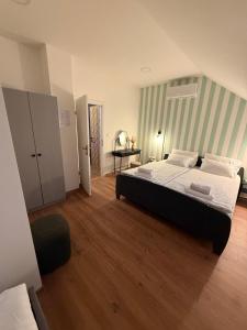a bedroom with a large bed with a green striped wall at Kuća za odmor Gaia in Vukovar
