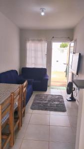 a living room with a blue couch and a table at Casa Aconchegante S8km do parque do peão in Barretos