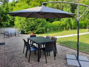 a black table and chairs under an umbrella at Le Petit Moulin de Verberie in Verberie