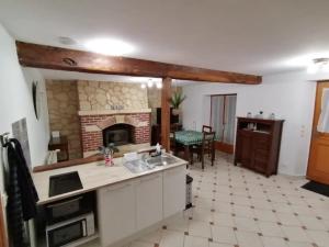a kitchen with a brick fireplace and a table at Le Petit Moulin de Verberie in Verberie +9 photos