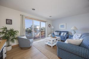 a living room with a couch and chairs and a window at 4203 - Here Comes the Sun in Duck