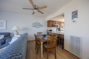 a living room with a bed and a table and chairs at 4203 - Here Comes the Sun in Duck