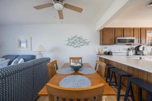 a kitchen and dining room with a table and a couch at 4203 - Here Comes the Sun in Duck +29 photos