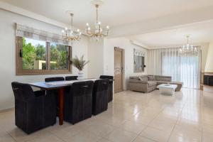 a dining room and living room with a table and chairs at Sunny Palm Villa in Ialysos