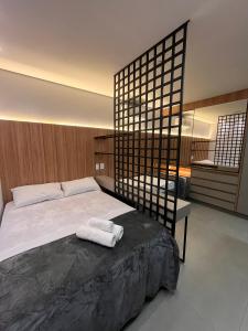 a bedroom with a bed with two towels on it at Haven Residence in Uberlândia