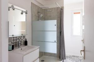 a white bathroom with a shower and a sink at Le Cadélac - appartement centre ville cosy in Loudéac
