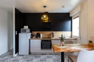 a kitchen with a white refrigerator and a table at Le Cadélac - appartement centre ville cosy in Loudéac +13 photos