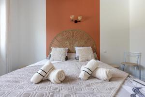 a bedroom with a bed with pillows on it at Le Cadélac - appartement centre ville cosy in Loudéac