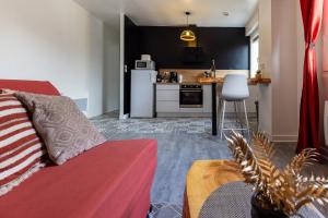 a living room with a couch and a kitchen at Le Cadélac - appartement centre ville cosy in Loudéac
