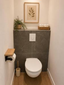 a bathroom with a white toilet and some plants at LE 23 ter in Jarny