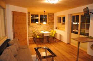 a living room with a couch and a table and chairs at Romantikappartement Petz**** in Donnersbachwald