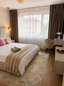 a bedroom with a large bed with a large window at A&K Apartament in Bacău