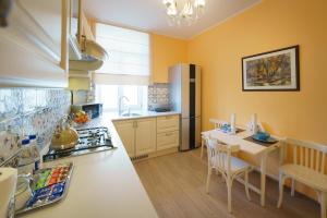 a kitchen with yellow walls and a table with chairs at PaulMarie Apartments on Mayakovskogo 24 in Brest