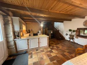 a kitchen with white cabinets and a wooden ceiling at Le Breizh des Bois in Le Faouët
