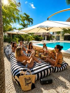 a group of people sitting on lounge chairs by a pool at Villa Luxauthentika Tulum in Tulum
