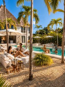 a group of people sitting around a pool at a resort at Villa Luxauthentika Tulum in Tulum